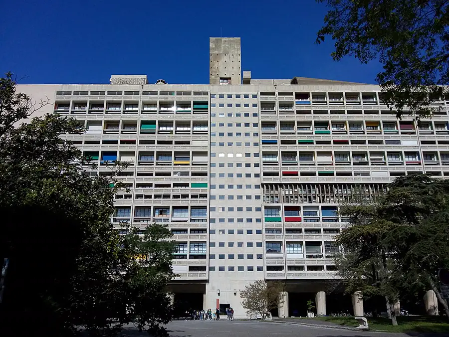 Unite d'Habitation de Marselha: fachada de concreto bruto com varandas coloridas, predio sobre pilotis macicos, marco do brutalismo
