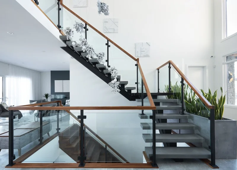 Guarda-corpo interno em vidro com perfil U embutido e estrutura de aço inox combinada com madeira em escada residencial