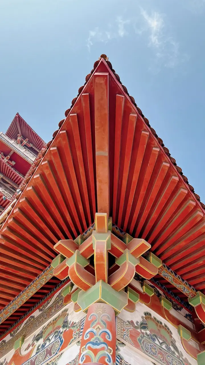 Detalhe de telhado chinês tradicional com beiral curvo vermelho e blocos de madeira do sistema dougong
