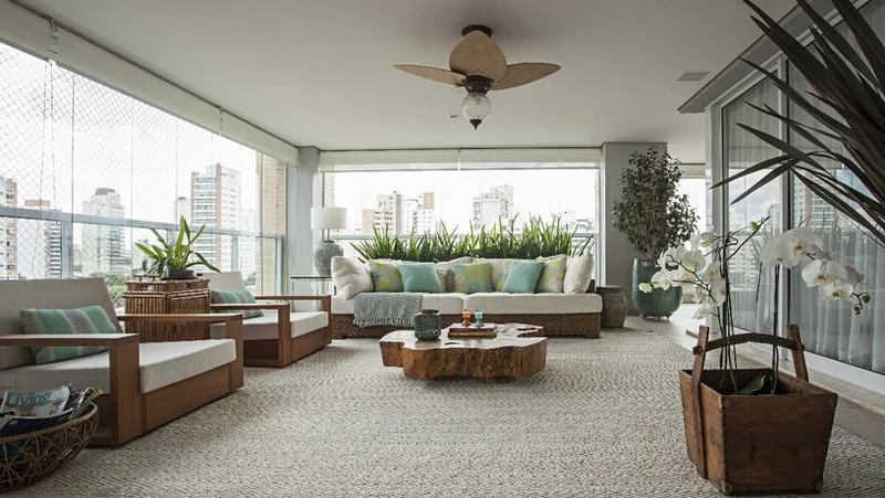 Varanda gourmet integrada a sala com vista urbana, mobiliario de madeira macica e tapete sisal em projeto de arquitetura de interiores