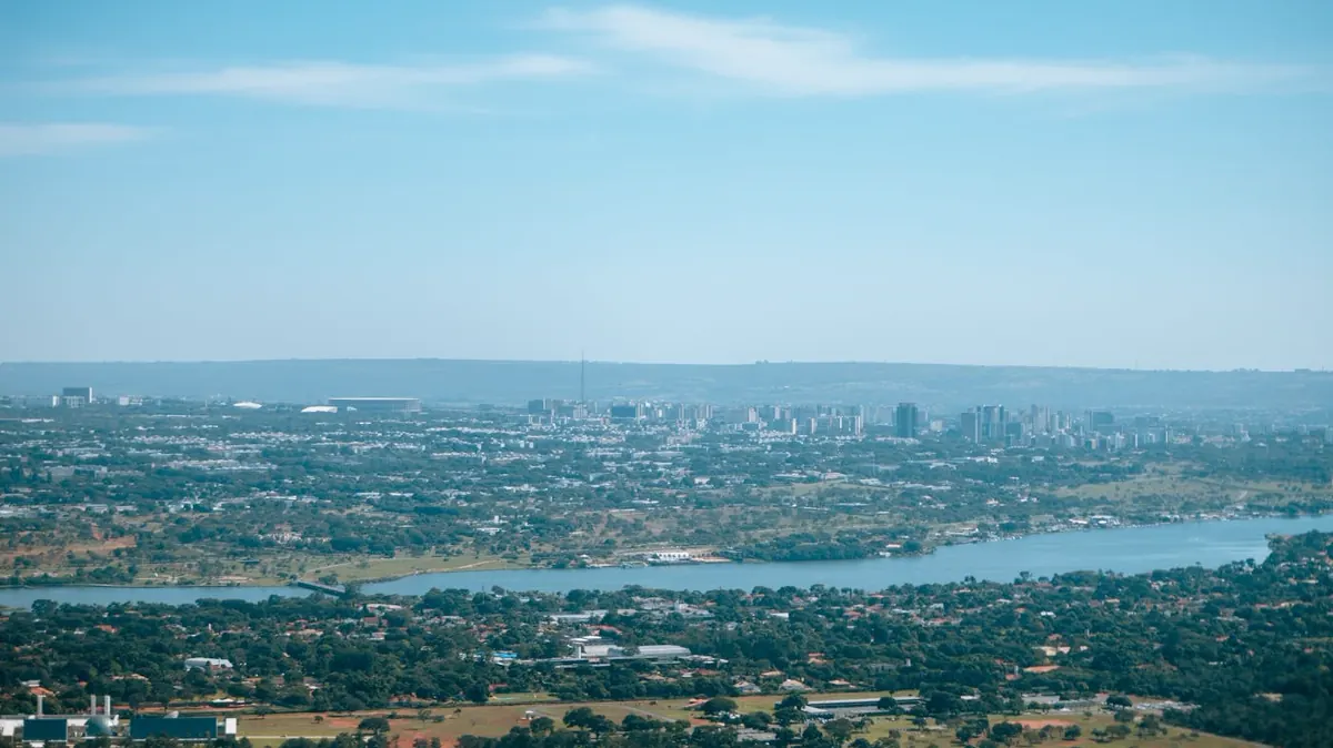 Vista aérea de Brasília mostrando o Lago Paranoá, áreas verdes e setores urbanos do Plano Piloto