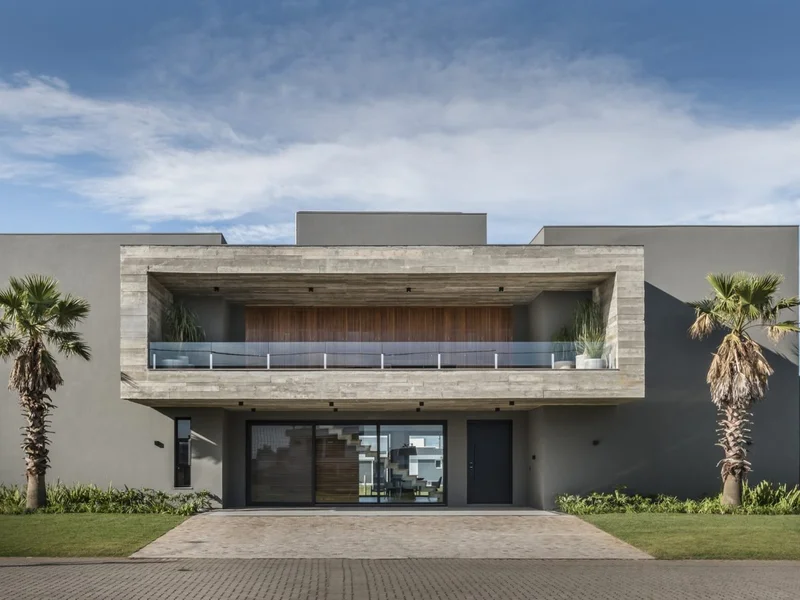 Volume residencial em concreto aparente com cobertura ventilada e brise integrado, mostrando estratégia de conforto térmico para clima tropical brasileiro