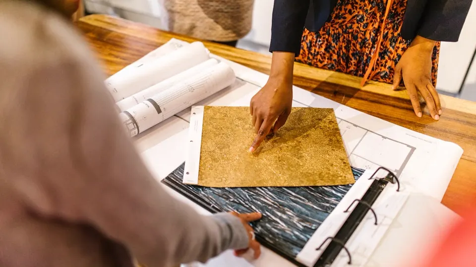 Equipe de arquitetura analisando amostras de materiais e plantas — portfólio e especialização