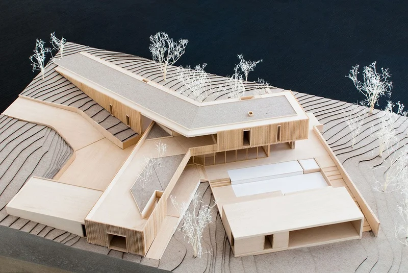Maquete arquitetônica em escala 1:200 com entourage de árvores em palitos e topografia em camadas