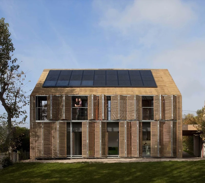 Edifício passivo certificado Passivhaus na Alemanha com fachada de venezianas de madeira e painéis solares