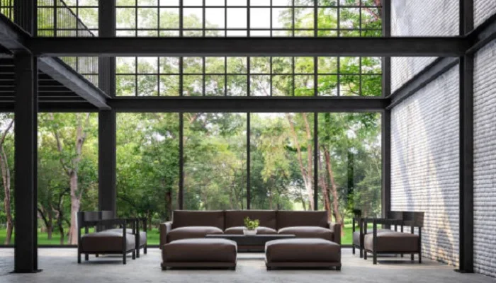 Sala com pé-direito alto de 4 metros e vidros até o teto mostrando proporção real do ambiente
